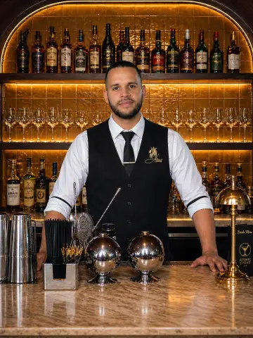 Bartender in front of a gold back-bar