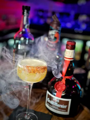 Chili-rimmed margarita through the smoke